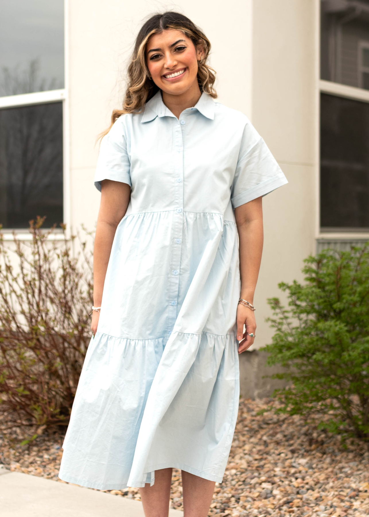 Front view of a blue button up dress with a collar