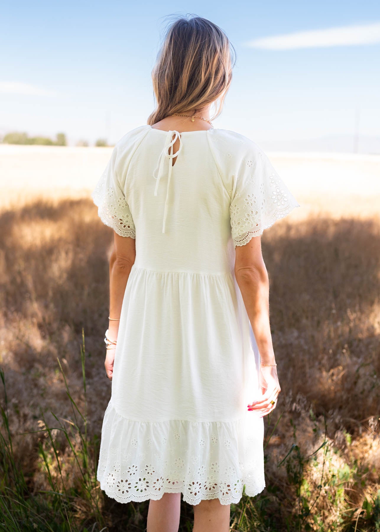 Back view of the ivory eyelet sleeve dress and the tie closer on the back