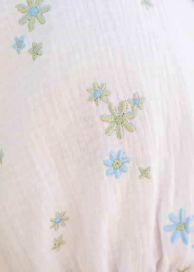 Close up of the fabric and flowers on the white flower embroidered dress