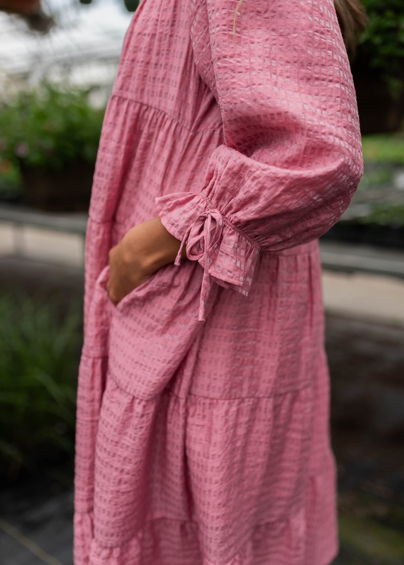 Close up of the fabric and pocket on the pink long sleeve dress