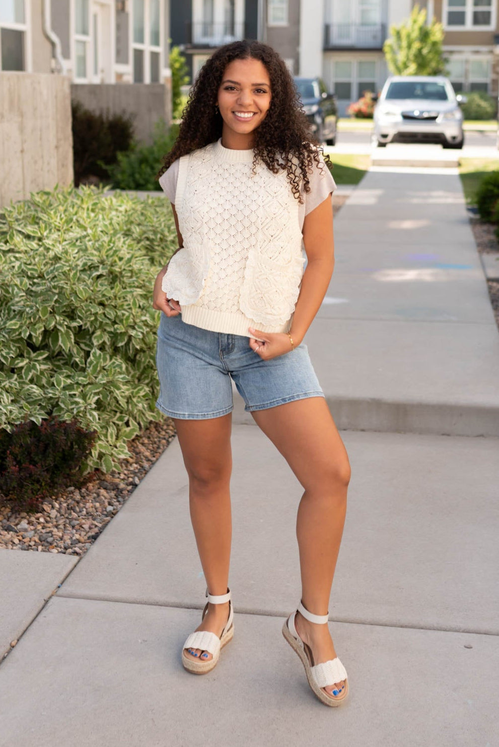 Cream knit sweater vest with lace around the pockets