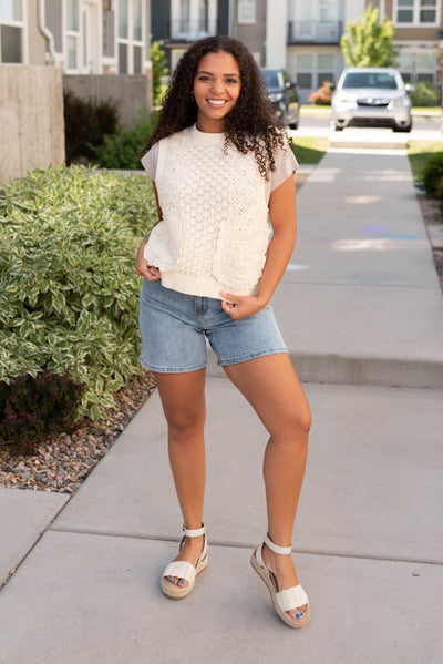 Cream knit sweater vest with lace around the pockets