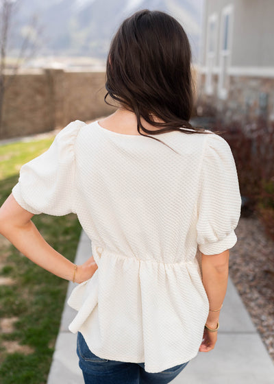 Back view of the cream ruffle top