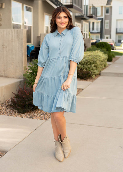 Knee length chambray tiered dress with short sleeves and pockets with button up bodice