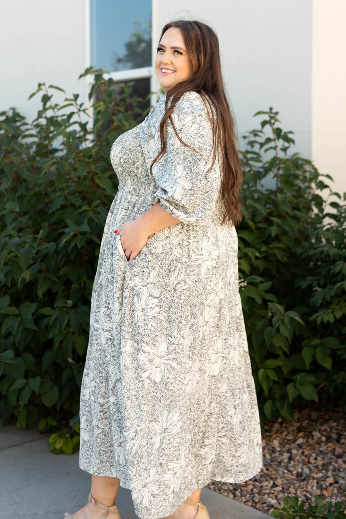 Side view of a plus size floral dress with pockets
