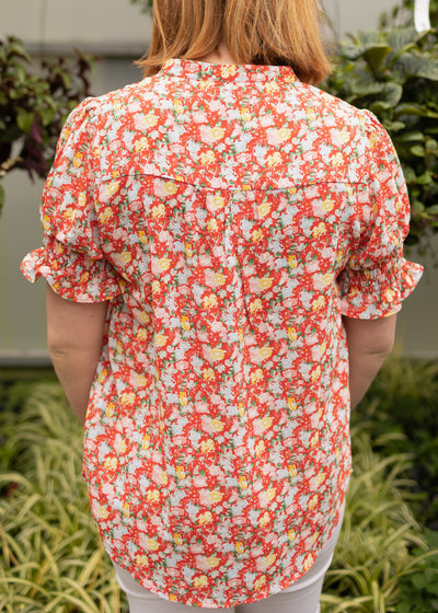 Back view of a red floral top that has short sleeves