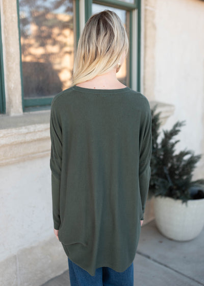 Back view of the dark green pocket sweater
