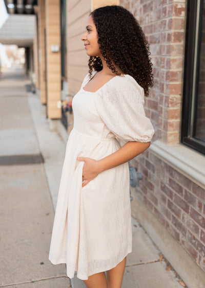 Side view of the cream square neck dress with pockets