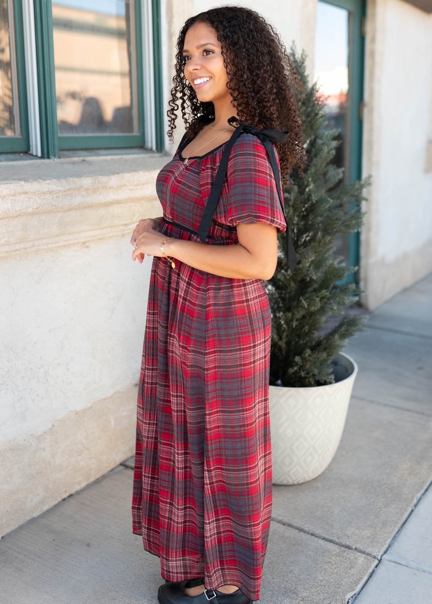 Side view of the red plaid bow dres with smocked bodice