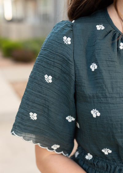 Close up of the fabric and sleeve on the dark teal floral dress