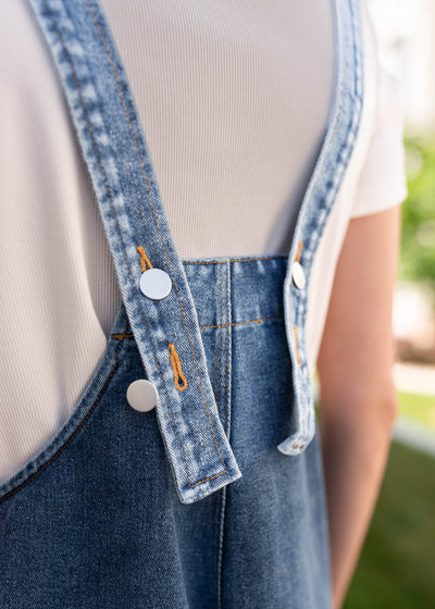 Back view of the adjustable straps on the denim overalls