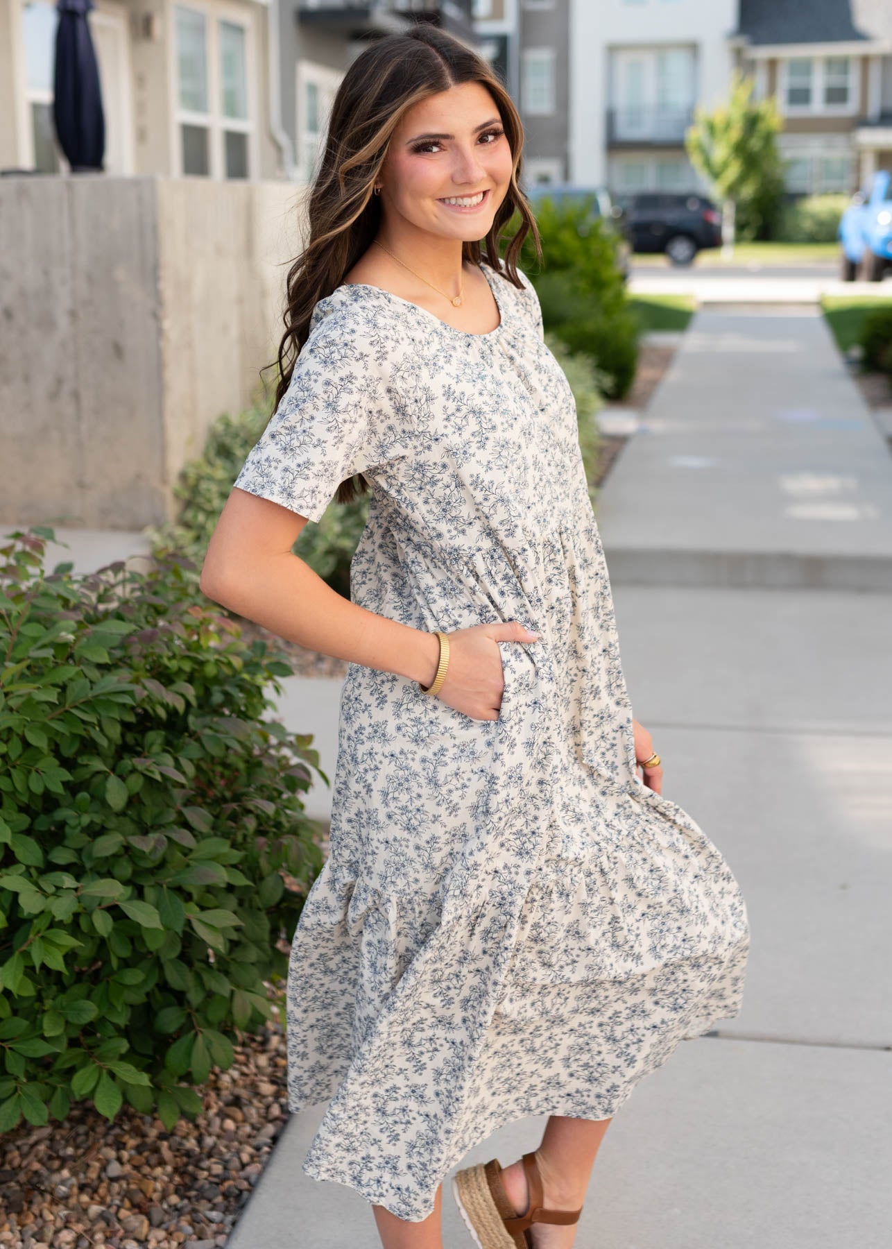 Side view of the cream floral tiered dress with pockets and navy flowers