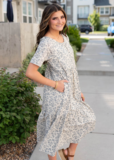 Side view of the cream floral tiered dress with pockets and navy flowers