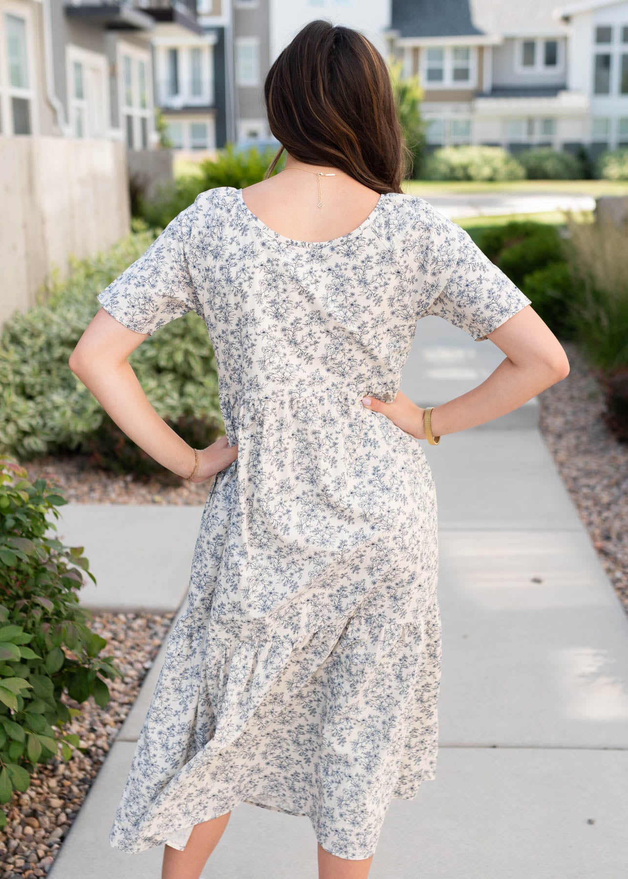 Back view of the cream floral  tiered dress with navy flowers
