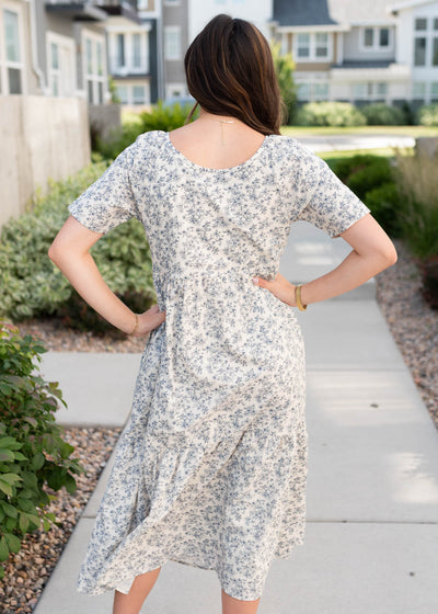 Back view of the cream floral  tiered dress with navy flowers