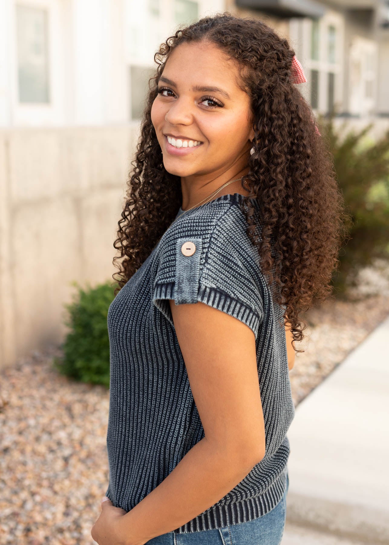 Side view of the modest navy knit sweater with button on the shoulder