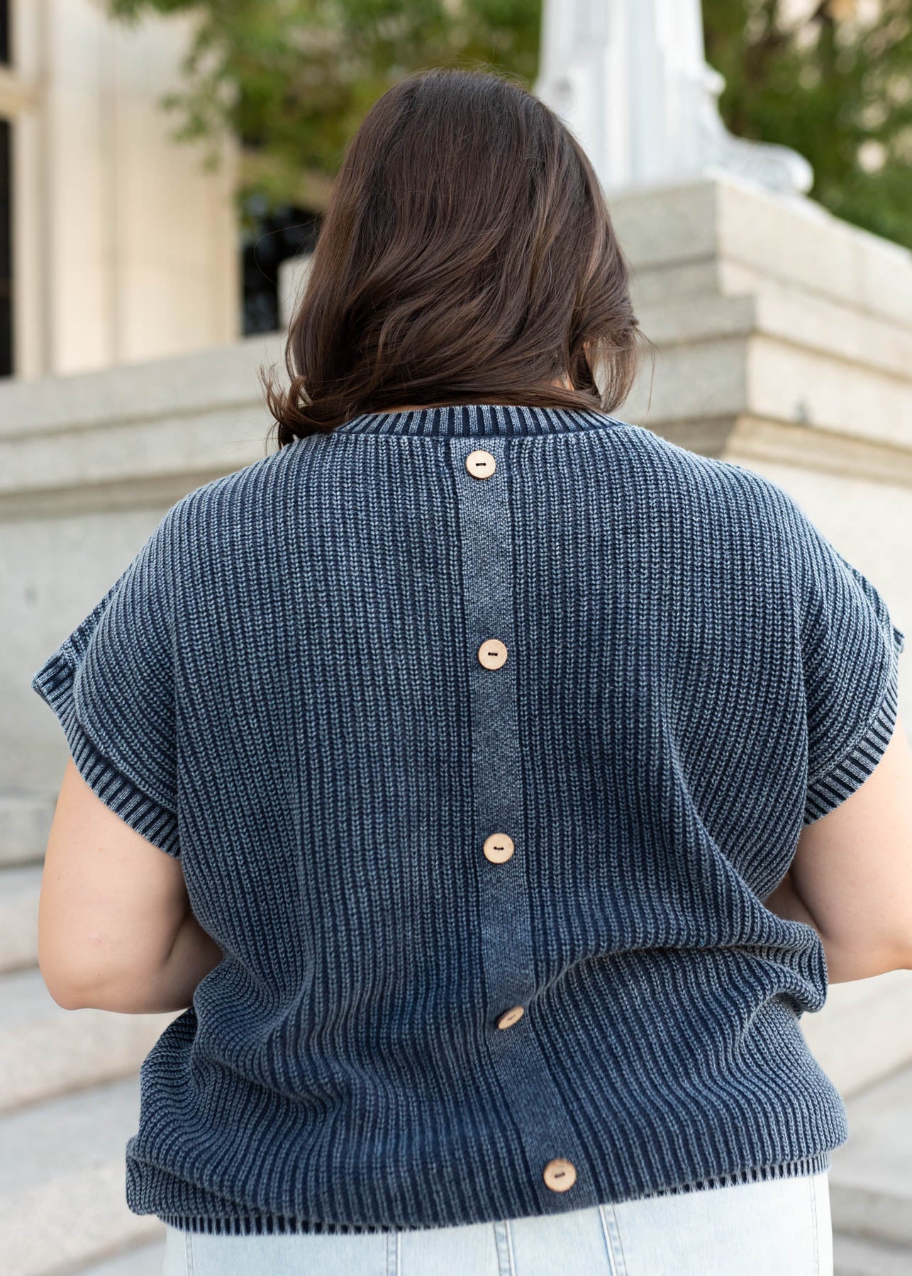 Back view of the navy knit sweater with buttons up the back