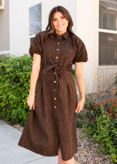 Short puff sleeves on the borwn leopard dress with brass snaps up of the front