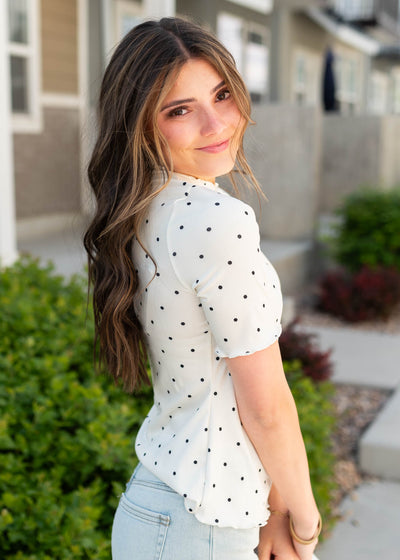 Side view of the cream polka dot ribbed top