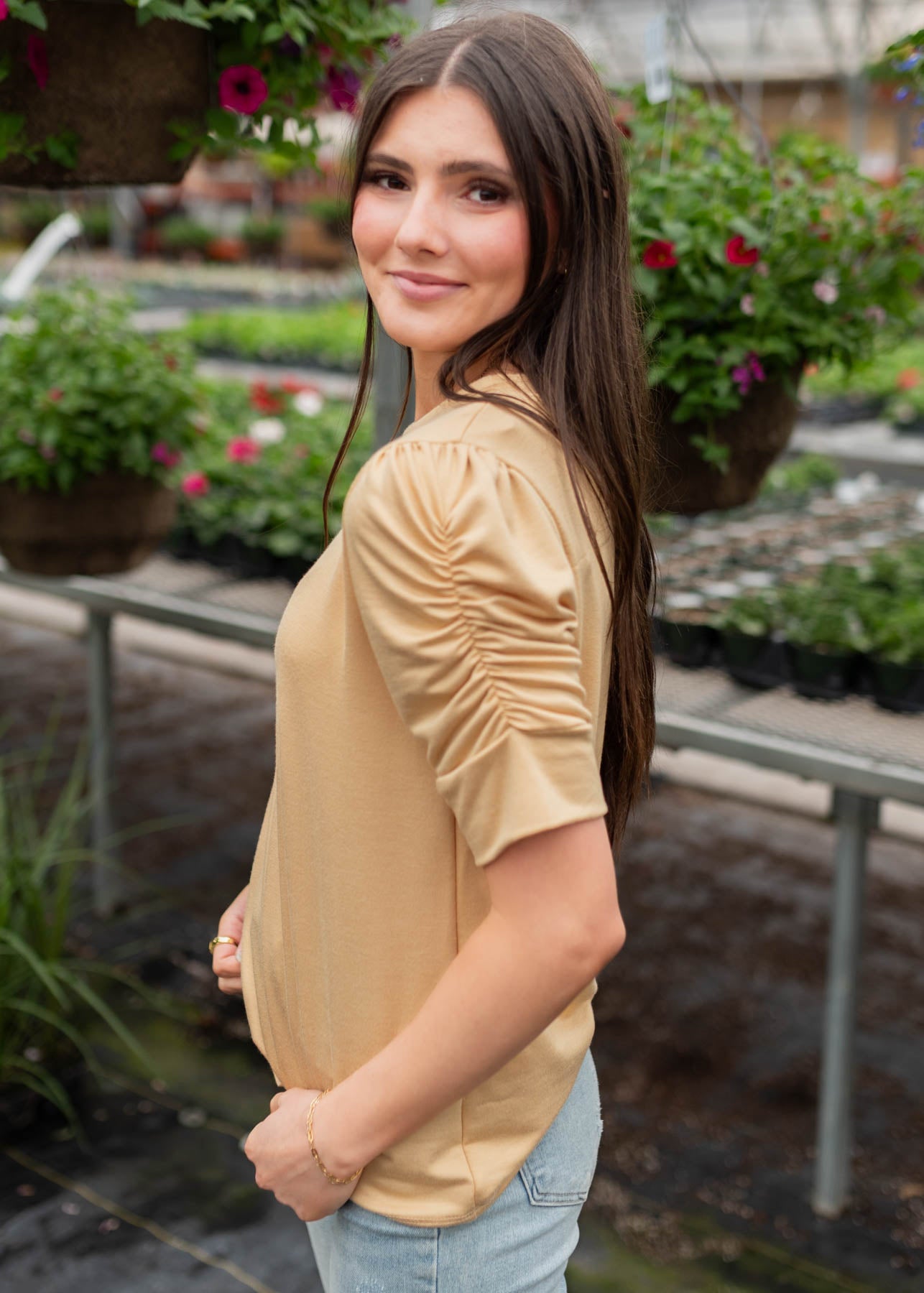 Side view of the light tan ruffle sleeve top