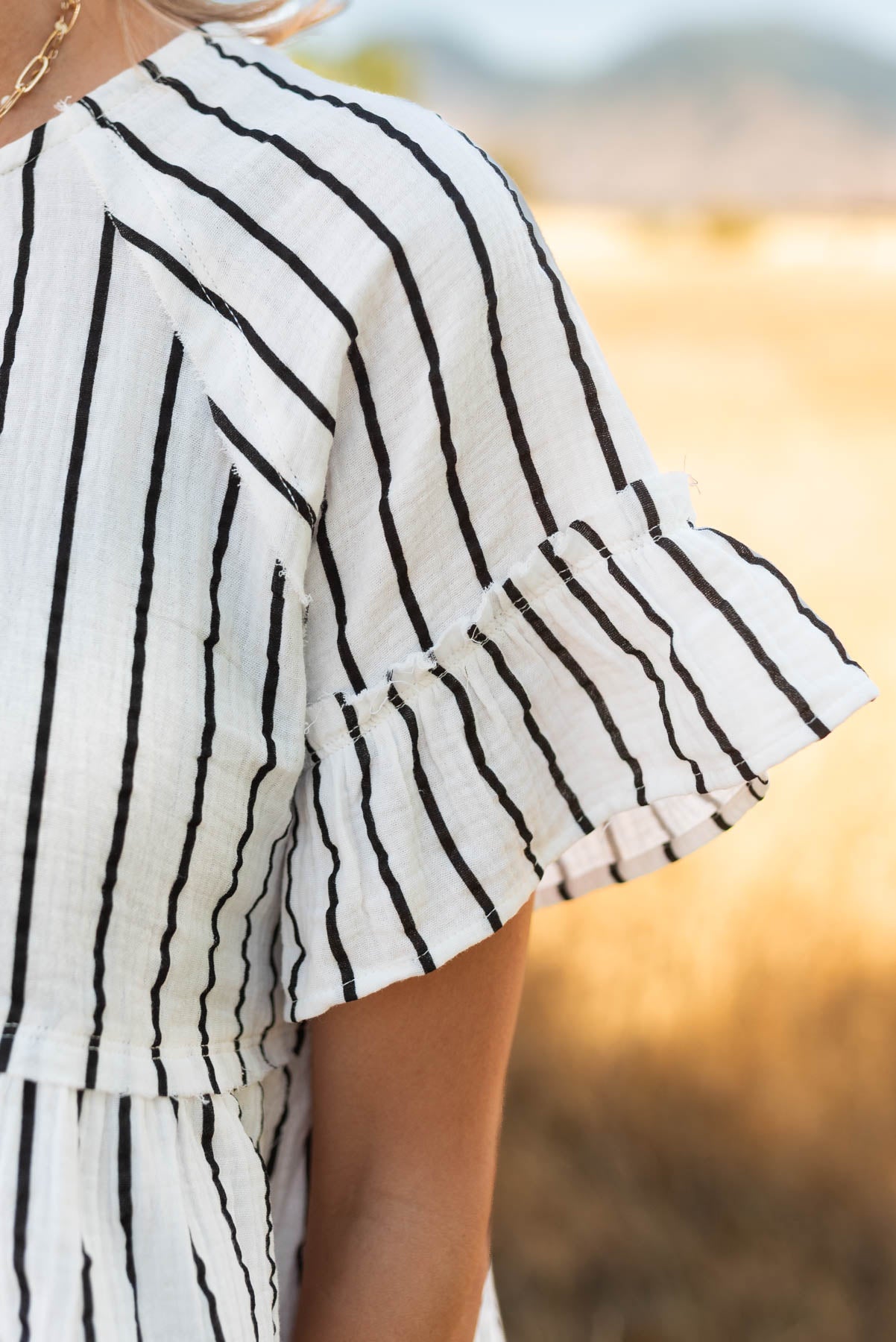 Close up of the sleeve and fabric on the  black striped peplum top