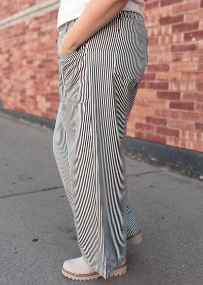 Side view of the navy pinstripe pants with pockets in plus size