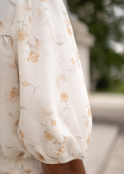 Close up of the fabric and sleeve on the cream floral smocked dress