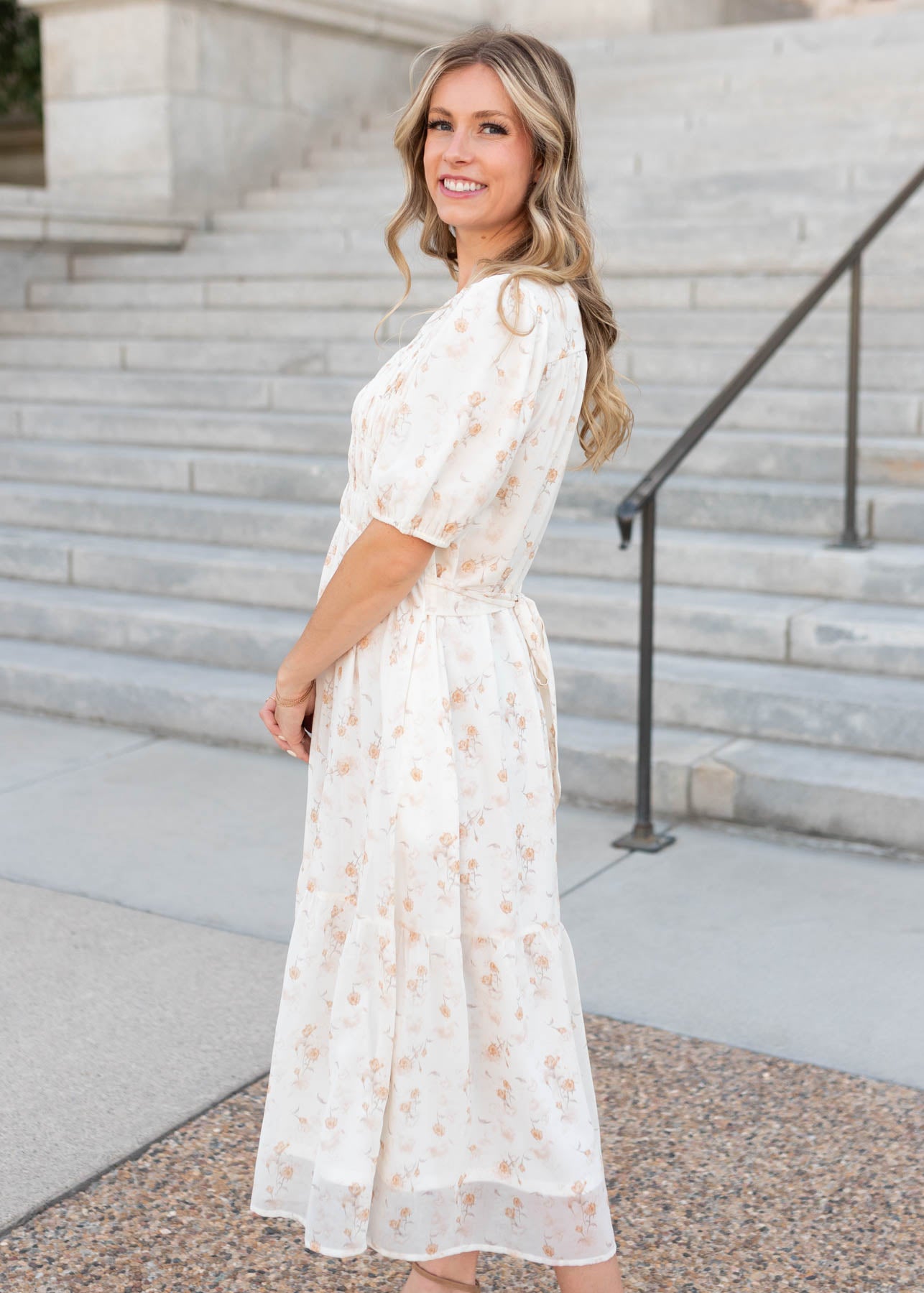Side view of the short sleeve lined cream floral smocked dress by Lena & Lou