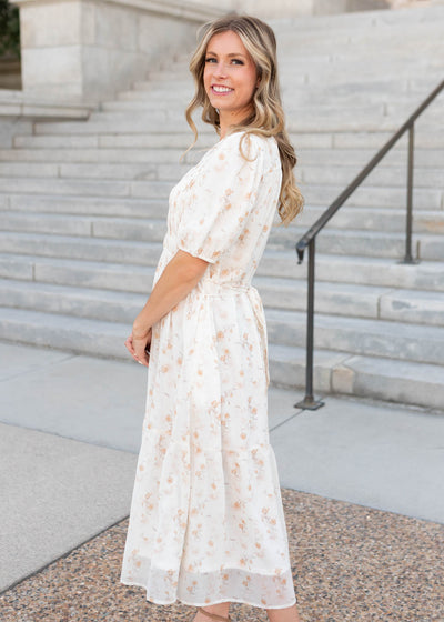 Side view of the short sleeve lined cream floral smocked dress by Lena & Lou