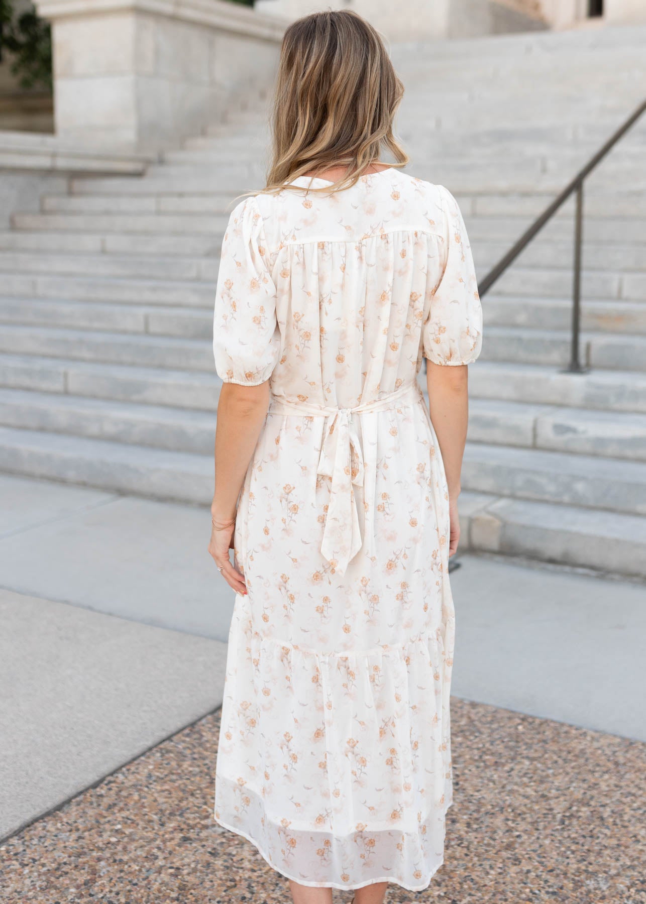 Back view of the modest cream floral smocked dress with a tie in the back