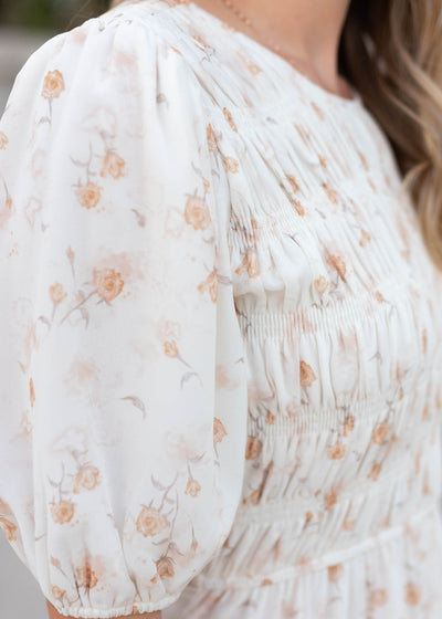 Close up of the fabric and sleeve on the cream floral smocked dress