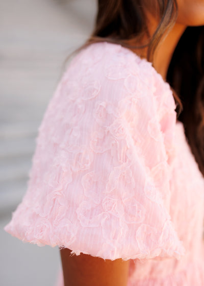 Close up of the fabric and sleeve on the pink floral textured dress