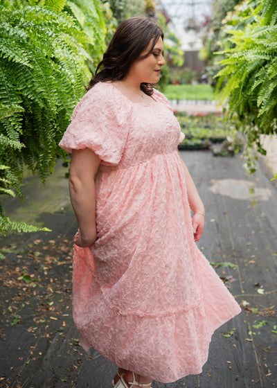 Side view of the plus size pink floral textured dress