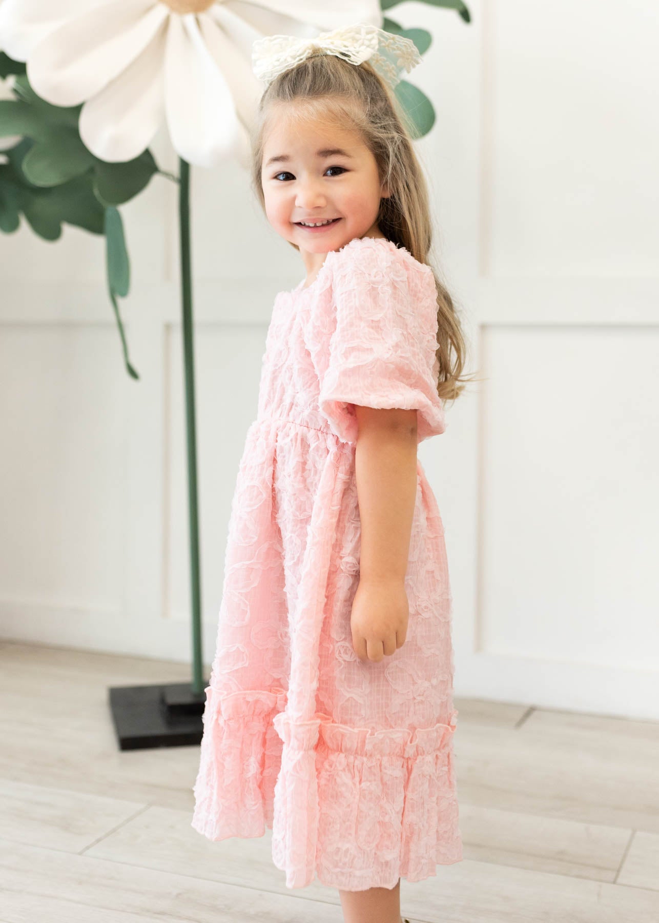 Side view of the pink floral textured little girl dress