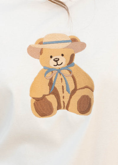 Close up of the embroidered teddy bear on the white teddy bear tee