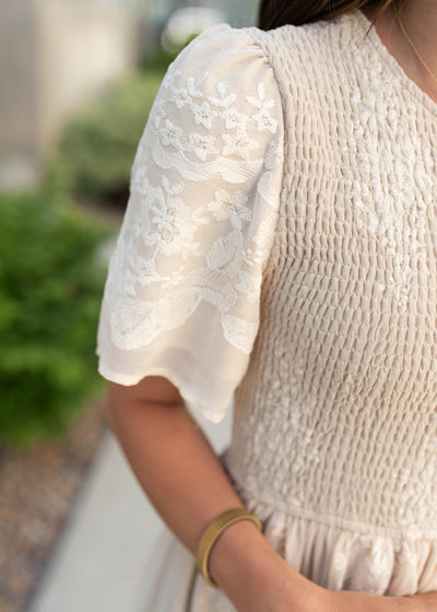 Close up of the fabric and sleeve on the champangne emboidered dress