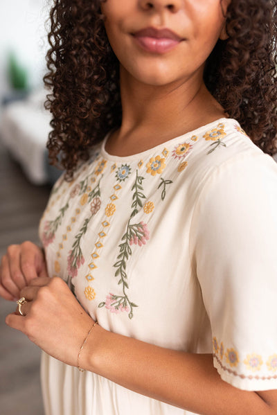 Close up of the embroidery on a cream dress