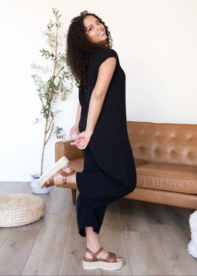 Side view of the black button up jumpsuit with crop sleeves