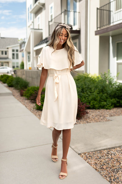 Short sleeve cream dress that is knee length