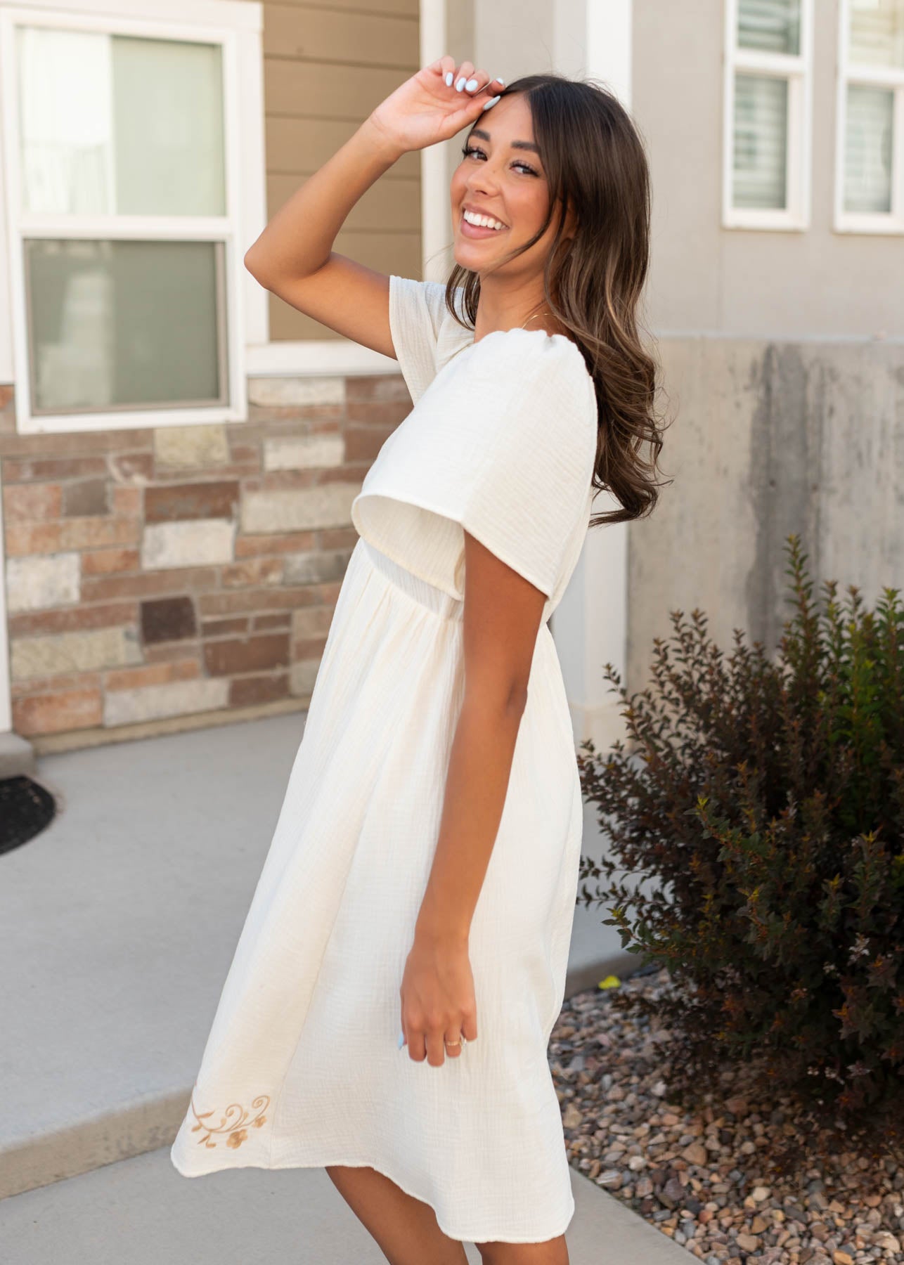 Side view of the ivory embroidered dress at Lena Layne