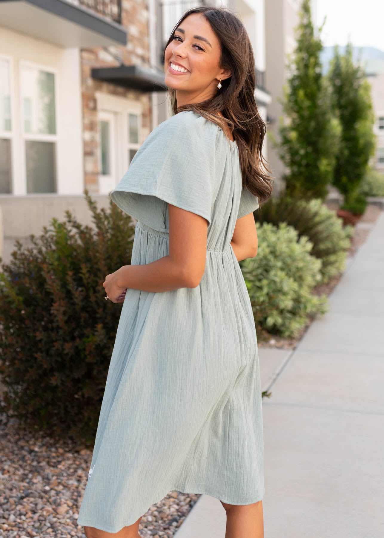 Side view of the modest light sage embroidered dress