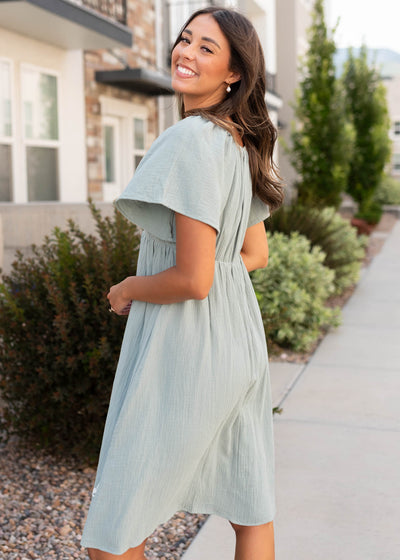Side view of the modest light sage embroidered dress