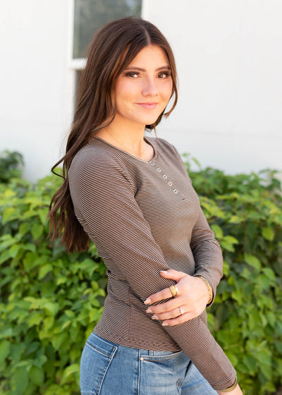Side view of the white and brown striped top with long sleeves
