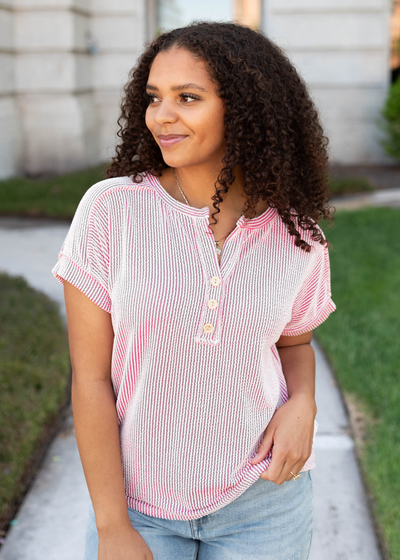 Buttons at the neck of the pink ribbed top