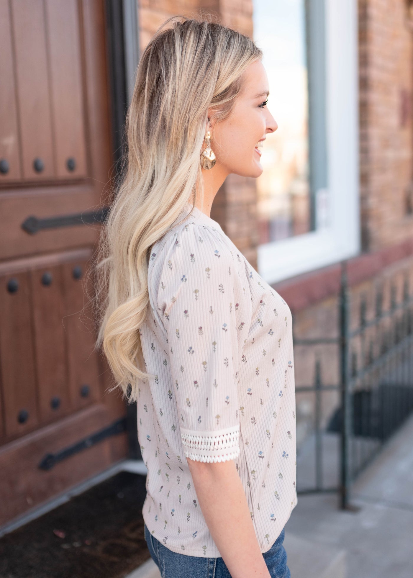 Side view of the cream floral to with lace on the cuff