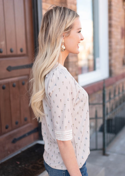Side view of the cream floral to with lace on the cuff