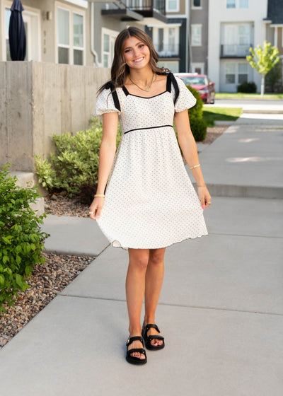 Knee length ivory polka dot dress with black trim