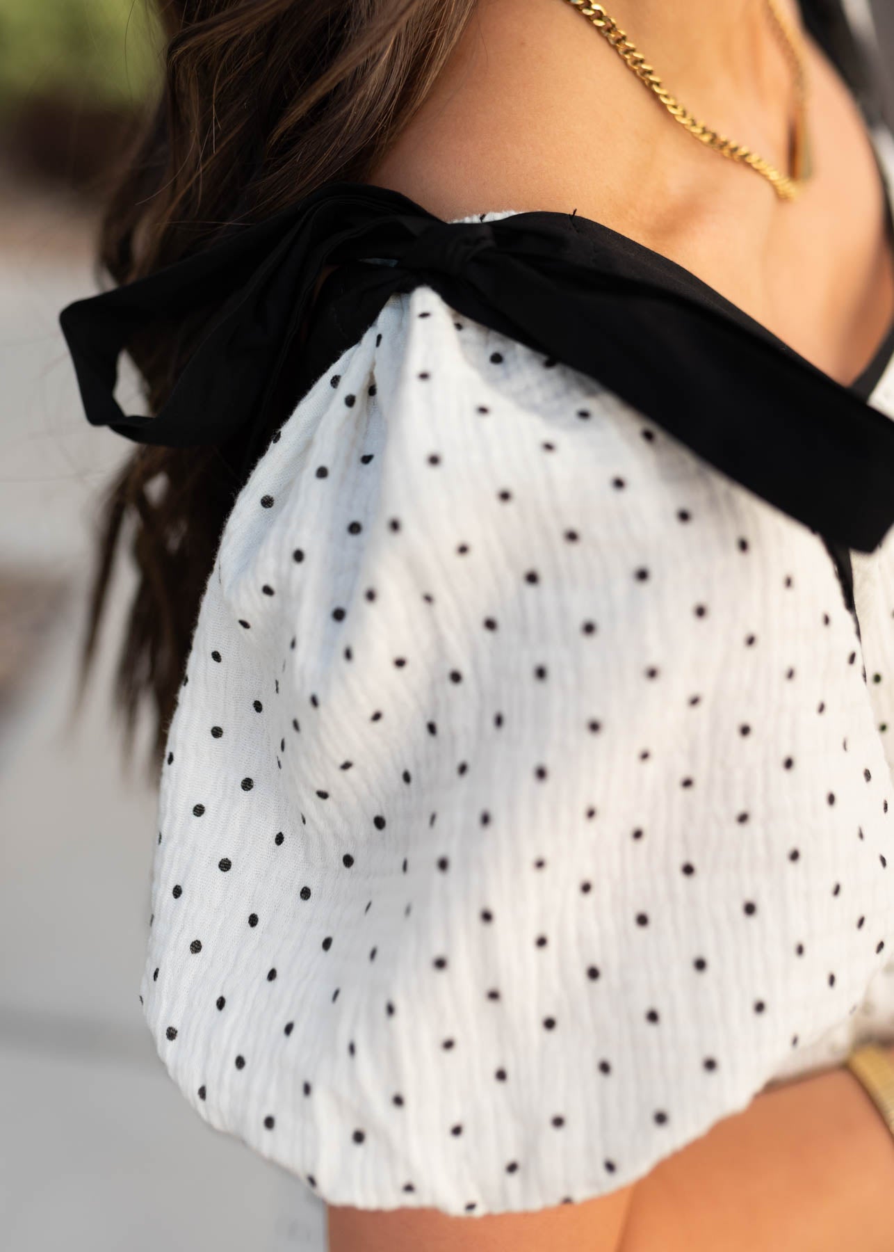 Close up of the sleeve and bow on the ivory polka dot dress