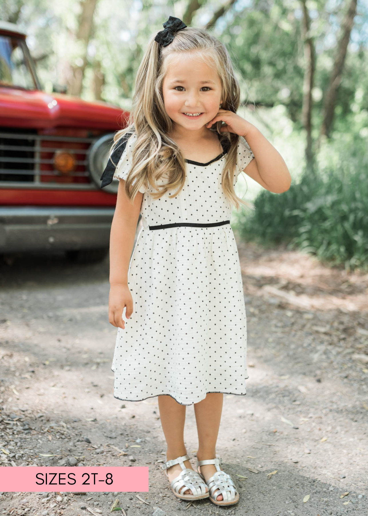 Black trim on the v-neck of the ivory polka dot little girl dress