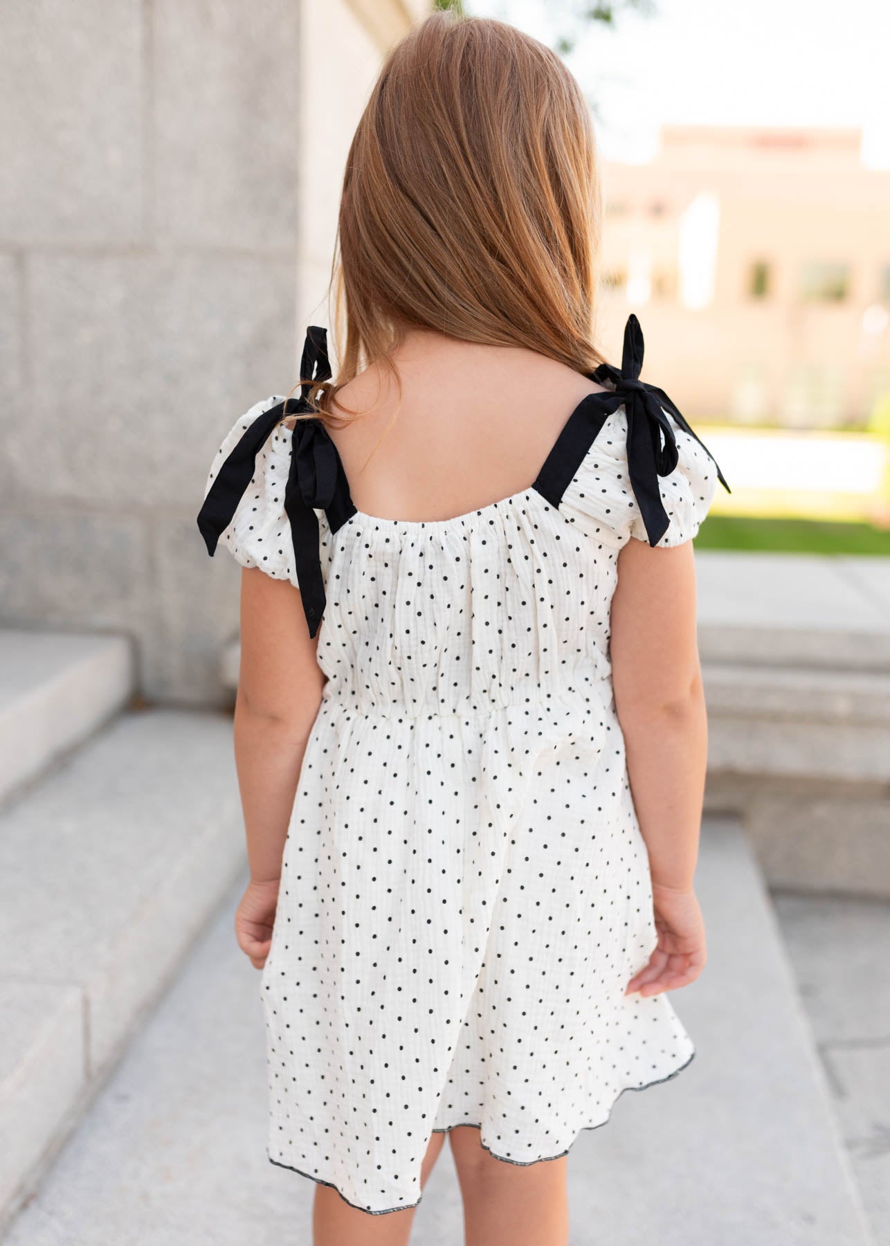 Back view of the ivory polka dot little girl dress